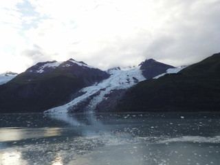 Glaciers within Glacier Bay National Park in Alaska. Glaciers coming over mountain peaks and sliding into the Pacific Ocean