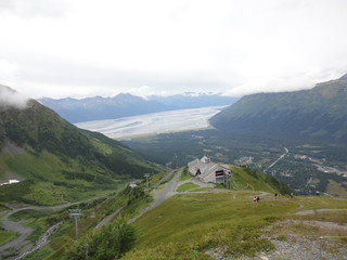 View from atop a mountain in the wilderness of Alaska. Peaks and ocean stretching off into the sky and clouds