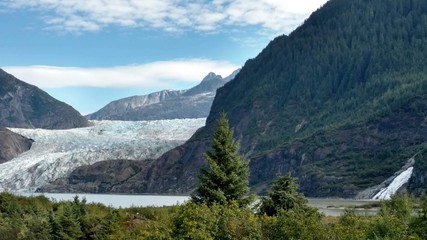Mendenhall Glacier Juneau Alaska. Mendenhall Glacier flowing into Mendenhall Lake in between mountains with Nugget falls. Perfect tourist location