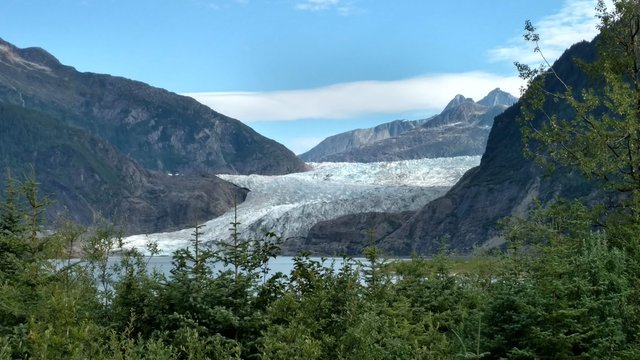 Mendenhall Glacier Juneau Alaska. Mendenhall Glacier flowing into Mendenhall Lake in between mountains with Nugget falls. Perfect tourist location