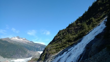 Naklejka na ściany i meble Mendenhall Glacier Juneau Alaska. Mendenhall Glacier flowing into Mendenhall Lake in between mountains with Nugget falls. Perfect tourist location