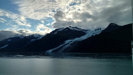 Glaciers within Glacier Bay National Park in Alaska. Glaciers coming over mountain peaks and sliding into the Pacific Ocean