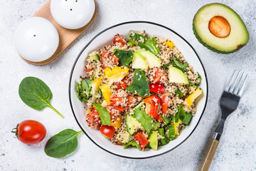 Quinoa salad with fresh vegetables on white.