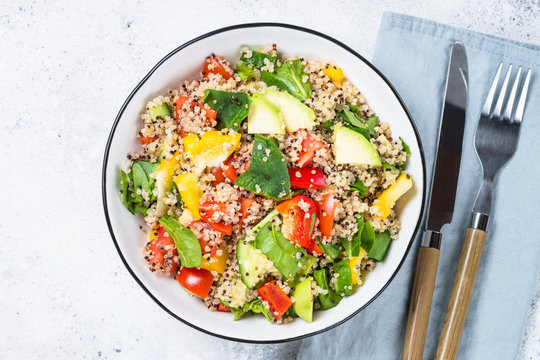 Quinoa salad with fresh vegetables on white.