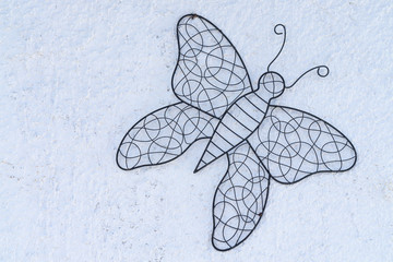 Butterfly made of metal as a decoration on a white house wall