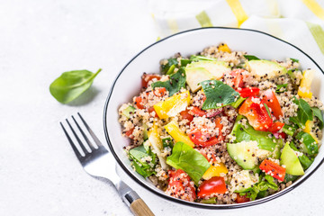 Quinoa salad with fresh vegetables on white.