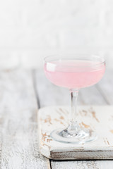 Summer refreshment drinks. Light pink rose cocktail, with rose wine on a white table. Copy space