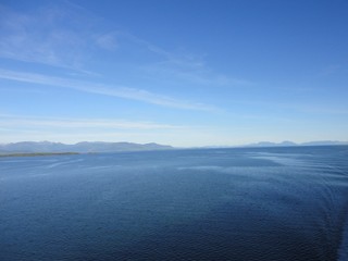 Fototapeta premium Calm Pacific Ocean in the inside passage in Alaska blue sky meets mountains and blue sea in a peacefully clear view