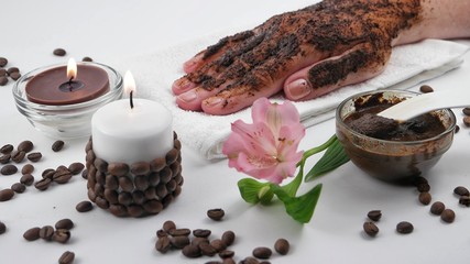 Female hand covered in coffee scrub. Coffee-based spa and aromatherapy accessories