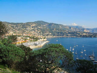 An overlook in the south of France with sailboats, houses on a hillside and a french city on a beautiful fall day.