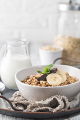 Healthy breakfast bowl. Granola with chocolate and banana on white wooden table. The concept of healthy nutrition and diet.