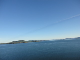 Passage in the Pacific Ocean between two mountain ranges. Calm peaceful waters flowing slowly under a cloudy sky.
