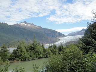 Fototapeta na wymiar Mendenhall Glacier Juneau Alaska. Mendenhall Glacier flowing into Mendenhall Lake in between mountains with Nugget falls. Perfect tourist location
