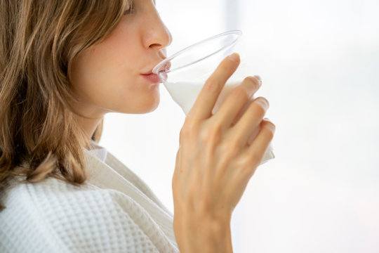 Happy Woman Wake Up In Early Morning, Breakfast Drinking Milk From A Glass  In Bed For Healthy Strong.  Lifestyle For Health Care  To Fulfilment Calcium,  Stronger Bones And Bright Skin For Health 