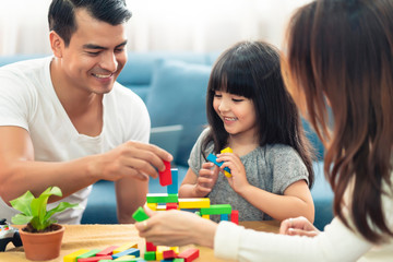 happy family caucasian and asian mixed race with pretty daughter enjoy family time with toy  together living room home background