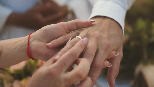 Exchange of rings at the wedding ceremony. Hands of bride and groom together
