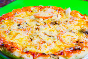 hot tasty fresh pizza on a plate close-up. green background
