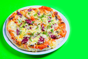 hot tasty fresh pizza on a plate close-up. green background