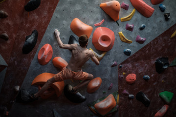 Athletic man practicing in a bouldering gym