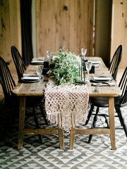 wedding cards on plates that stand on a wooden table surrounded by real flowers