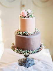 Closeup of wedding cake with flowers. cake on the cake-shelf. Cake decorated with pink and purple flowers 
