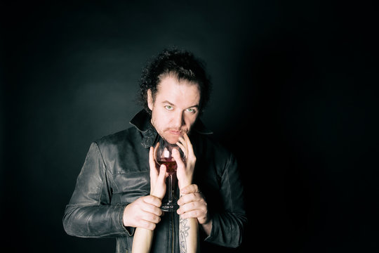 Love, passion and red wine. Two sexy guys. Black background.