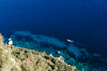 Yacht at the sea in Italy. Aerial view of luxury floating boat on transparent turquoise water at sunny day. Summer seascape from air. Top view from drone. Seascape with motorboat in bay.