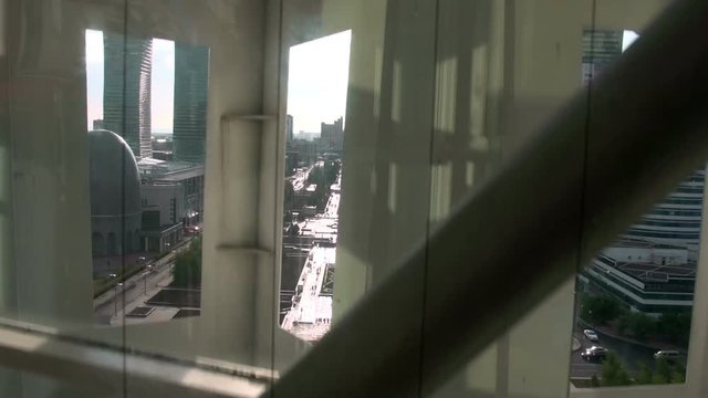 Rise by a Panoramic Lift. The camera moves up by a panoramic lift. Through architectural elements seen views of the city