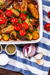Grilled chicken wings with baked potatoes and vegetables