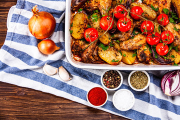 Grilled chicken wings with baked potatoes and vegetables
