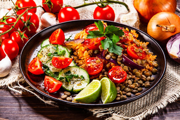 Groats with lentils and vegetables on wooden table