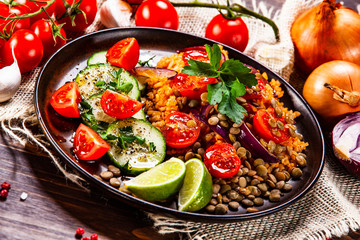 Groats with lentils and vegetables on wooden table