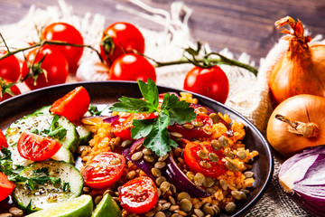 Groats with lentils and vegetables on wooden table