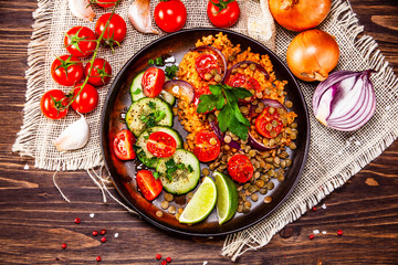 Groats with lentils and vegetables on wooden table