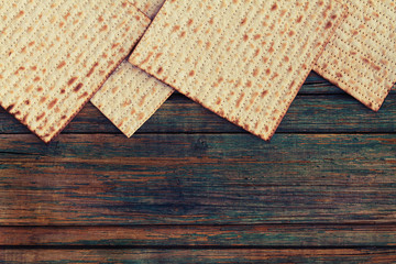 Four pieces of matzah or matza on a vintage wood background with copy space or text space.