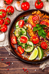 Groats with lentils and vegetables on wooden table