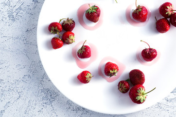 Strawberries in a white plate and yum typography made with jam. Close-up top view
