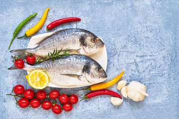 Fresh dorada fish with spices on wooden cutting board. Healthy food concept. Top view, copy space. Mediterranean seafood concept.
