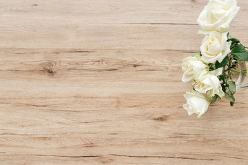 Top view of fresh white roses on wooden surface