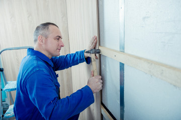 male builder revets wood panels for a facade of walls