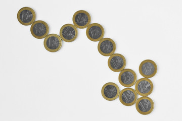 Downward arrow made of euro coins on white background - Concept of downward trend of euro currency