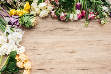 Top view of fresh colorful flowers on wooden surface