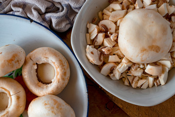 White mushrooms cut on a wooden table.