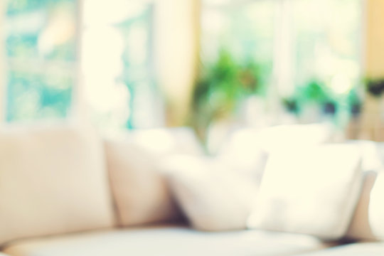 Blurred home interior background with couch and natural light