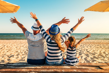 family in striped clothes on the beach