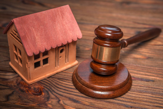 house, the judge's gavel on wooden background table. real estate, housing.