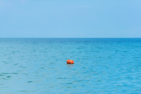 Red buoy on the surface of the sea. The texture of the surface of the water. Rest on black sea. The waves of the sea.