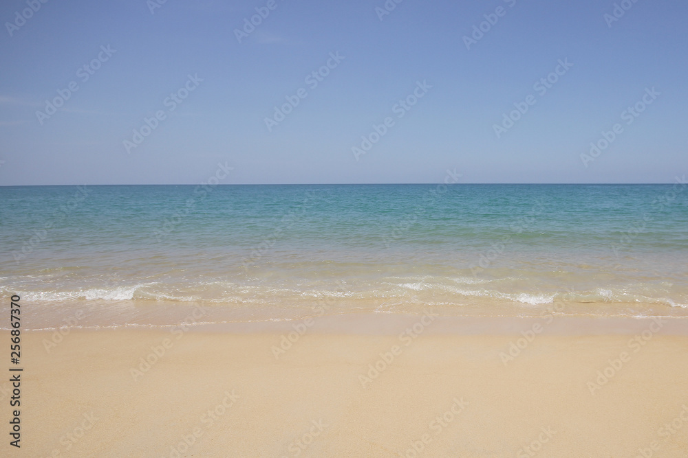 Wall mural Idyllic crystal beach and seawater in front of luxury hotel, attractive clear sea, nature coastline backgrounds during holidays sunbathing, wave from clear blue green sea and fine sand