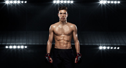 Fototapeta na wymiar Sportsman teenager boxer fighting on black background with shadow. Copy Space. Boxing sport concept.