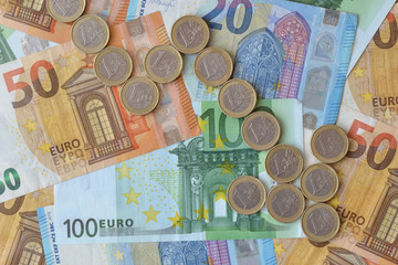 Downward arrow made of euro coins on euro banknotes background - Concept of downward trend of euro currency